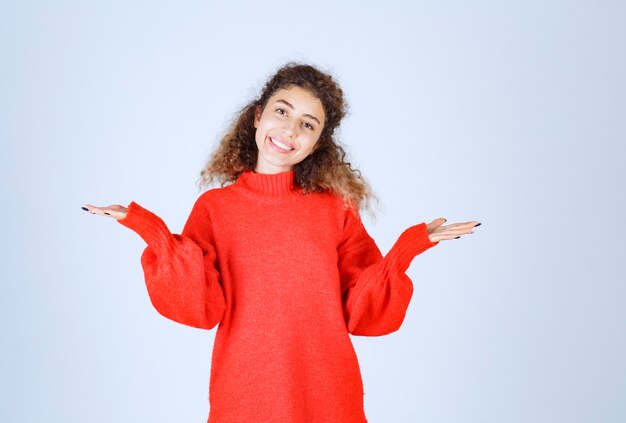 donna in felpa rossa che dà pose sorridenti e seducenti.