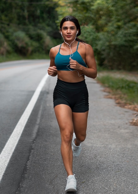 Donna in forma a tutto campo che corre all'aperto