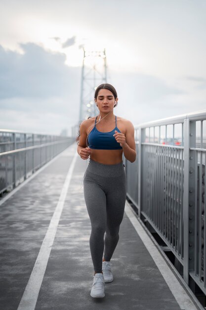 Donna in forma a tutto campo che corre all'aperto