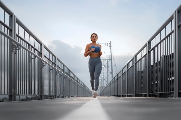 Donna in forma a tutto campo che corre all'aperto