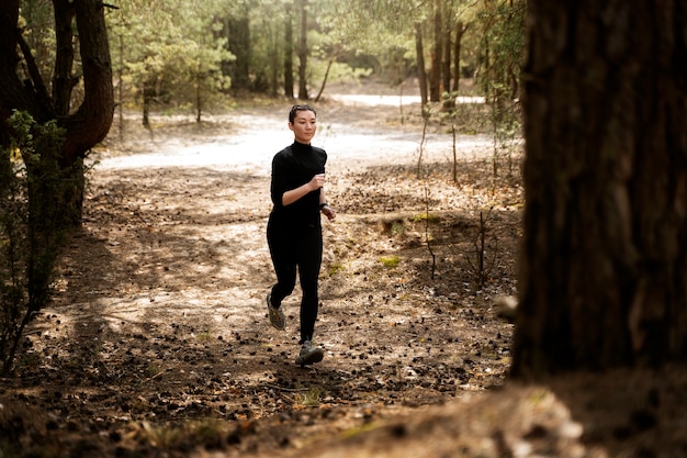 Donna in forma a tutto campo che corre in natura