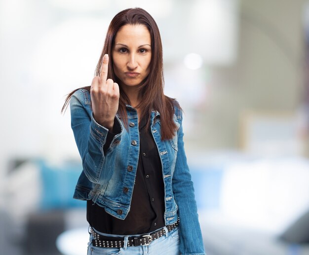 Donna in giacca di jeans che fa un gesto con la mano offensivo