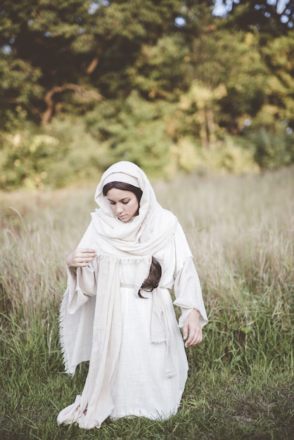 Donna in ginocchio mentre indossa un abito biblico