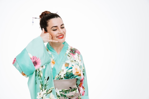 Donna in kimono tradizionale giapponese felice e positivo che mi chiama gesto su bianco