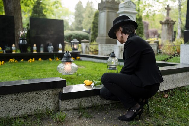 Donna in lutto nel cimitero accanto alla tomba