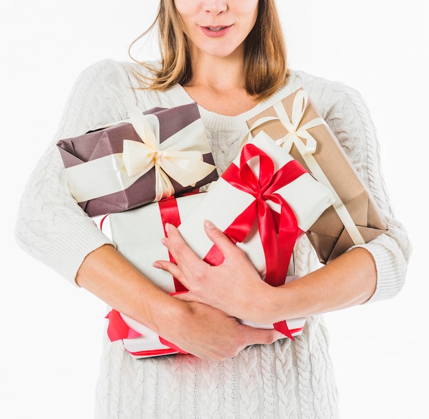 Donna in maglione in piedi con scatole regalo