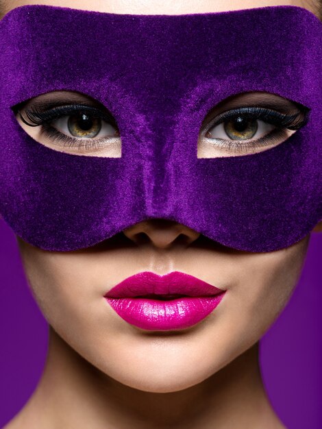 Donna in maschera teatrale viola sul viso con labbra viola