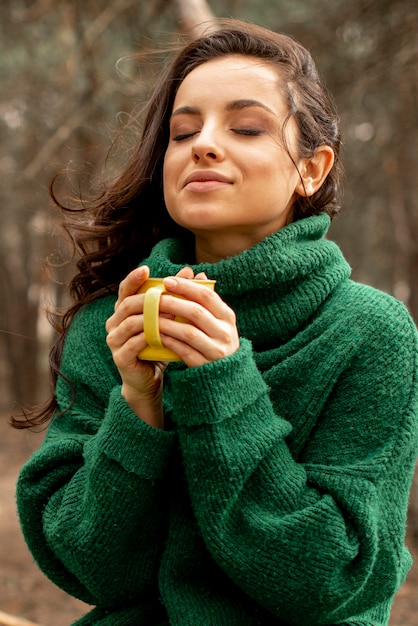 Donna in natura godendo il tè