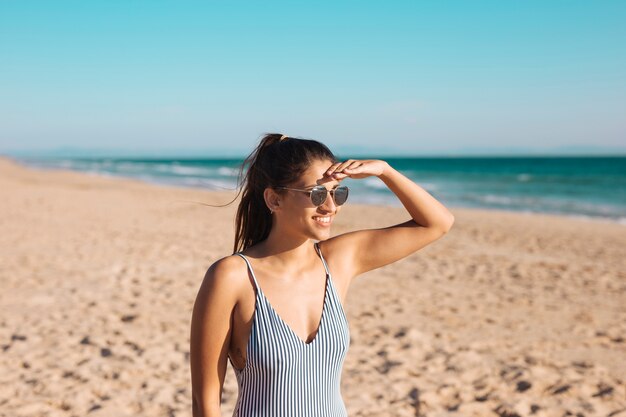 Donna in occhiali da sole sulla spiaggia