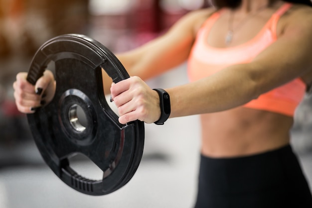 Donna in palestra che si esercita con piastra di peso