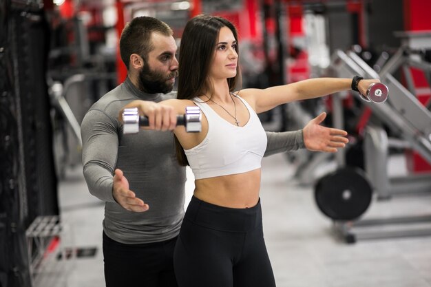 Donna in palestra con trainer