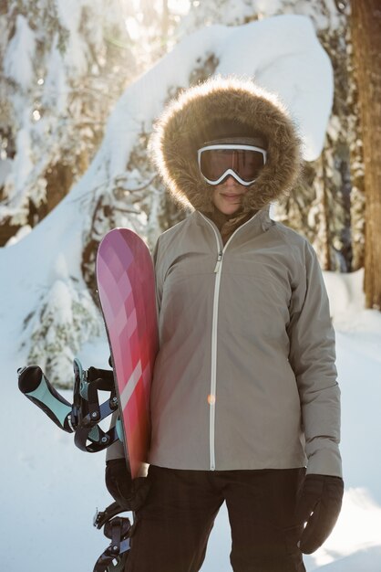 Donna in piedi e in possesso di uno snowboard