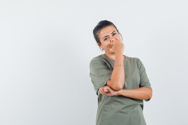 donna in piedi nella posa di pensiero in t-shirt e che sembra ragionevole