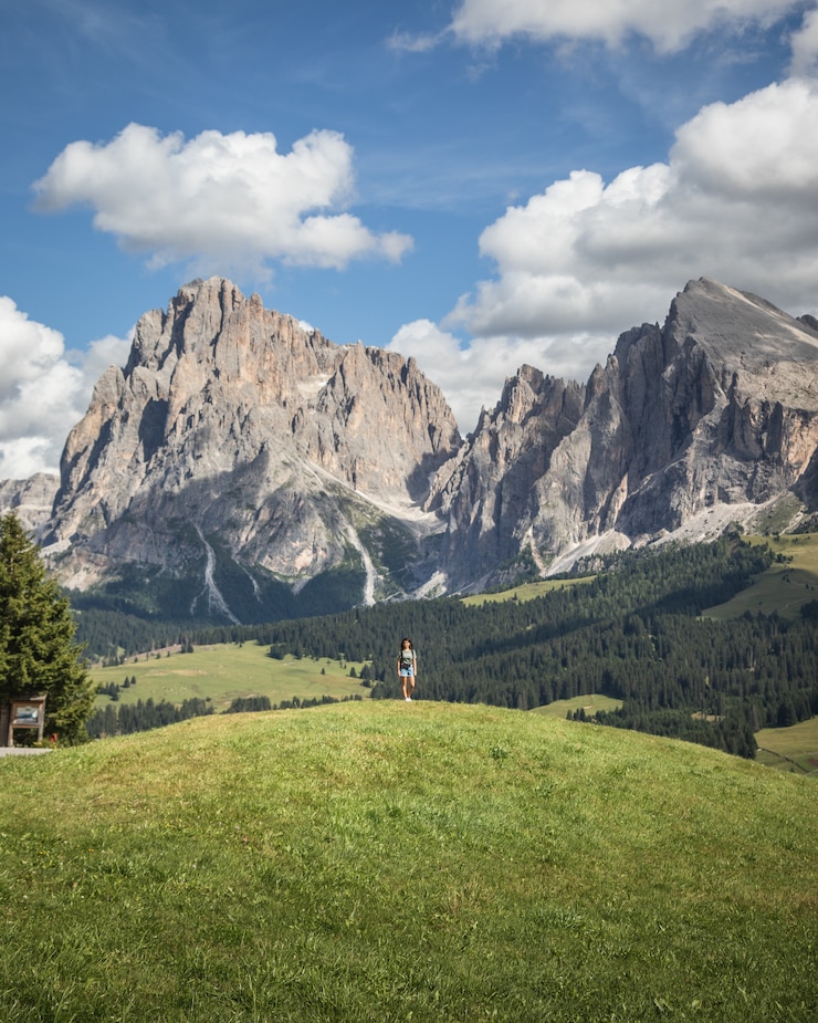 Foto gratuito donna in piedi su una collina con il sassopiatto come sfondo a compatsch italia