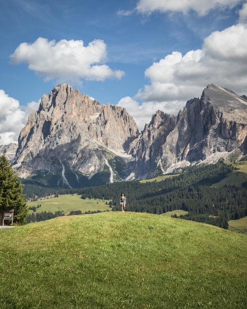 Donna in piedi su una collina con il Sassopiatto come sfondo a Compatsch Italia