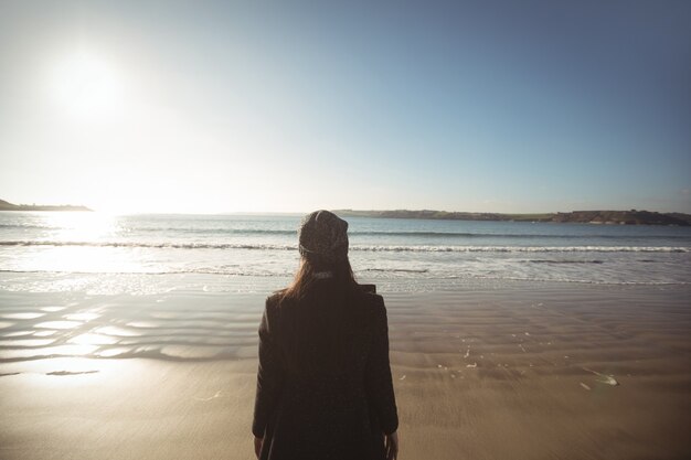 Donna in piedi sulla spiaggia durante il giorno