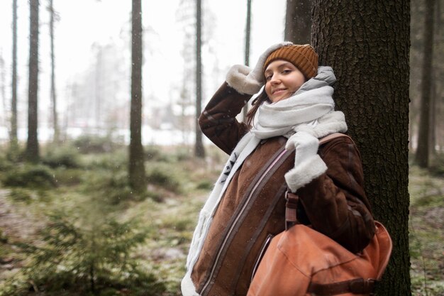 Donna in posa accanto a tre nella foresta durante un viaggio invernale