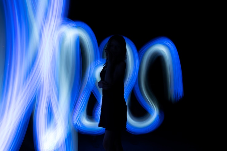 Foto gratuito donna in posa con la luce blu vista laterale