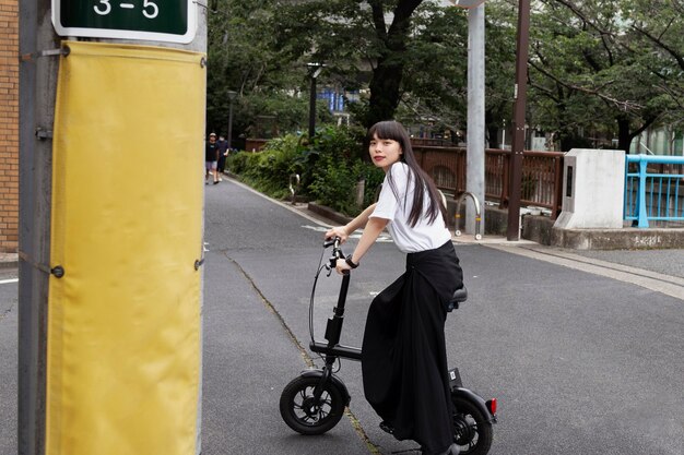 Donna in sella a uno scooter elettrico in città