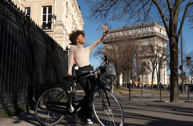 Donna in sella alla bicicletta e prendendo selfie in città in Francia