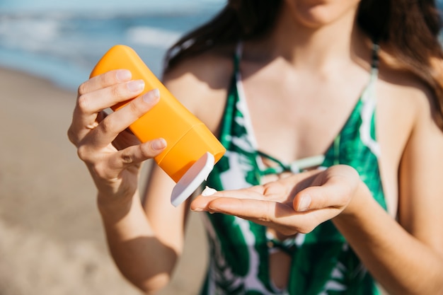 Donna in spiaggia con crema solare