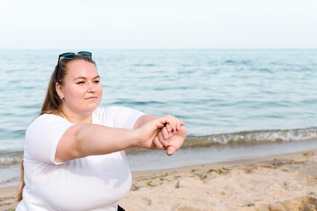 Donna in spiaggia facendo esercizi sportivi