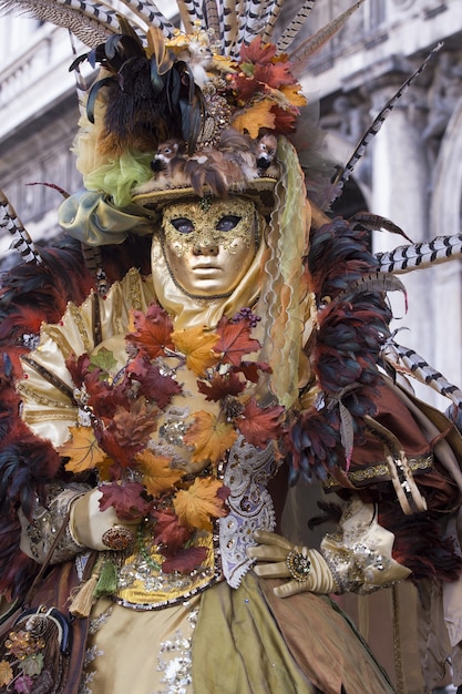 Donna in un bellissimo vestito e tradizionale maschera di Venezia durante il carnevale di fama mondiale
