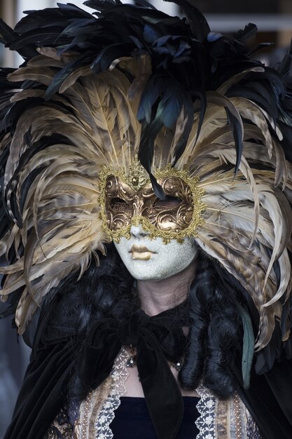 Donna in un bellissimo vestito e tradizionale maschera di Venezia durante il carnevale di fama mondiale