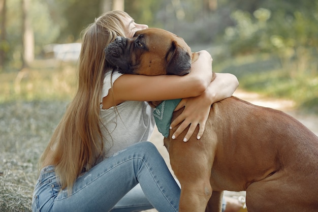 donna in un bosco estivo a giocare con il cane