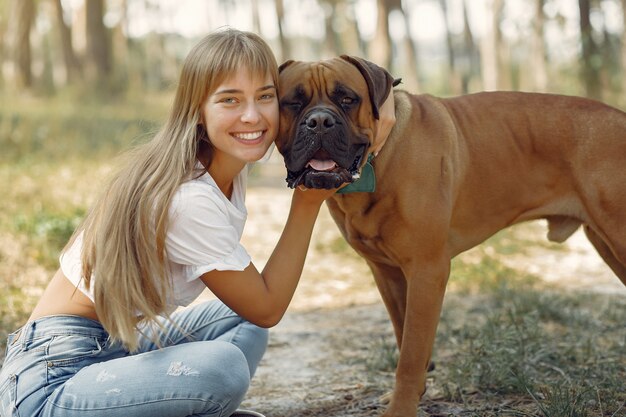 donna in un bosco estivo a giocare con il cane