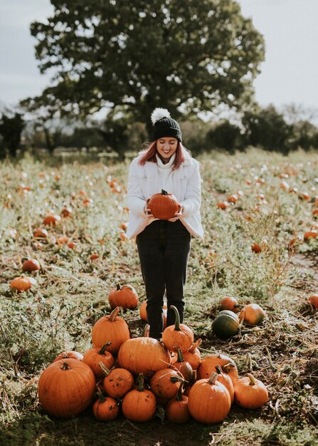 Donna in un campo di zucche prima di Halloween