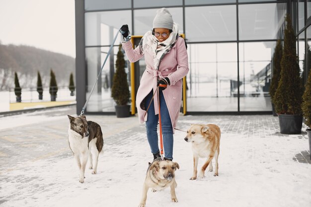 Donna in un cappotto rosa, cani che camminano