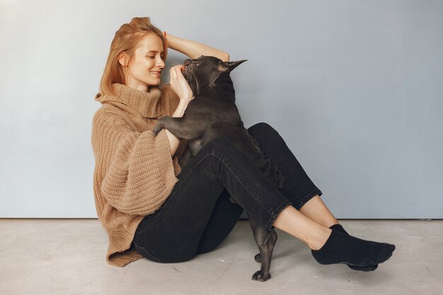 donna in un maglione marrone con bulldog nero