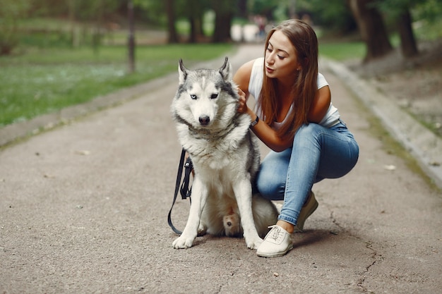 Donna in un parco di primavera che gioca con il cane carino