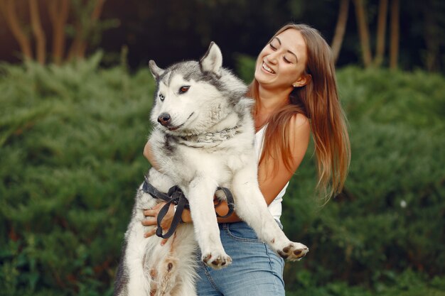 Donna in un parco di primavera che gioca con il cane carino