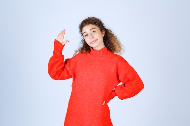 donna in una camicia rossa che si ferma e impedisce qualcosa.