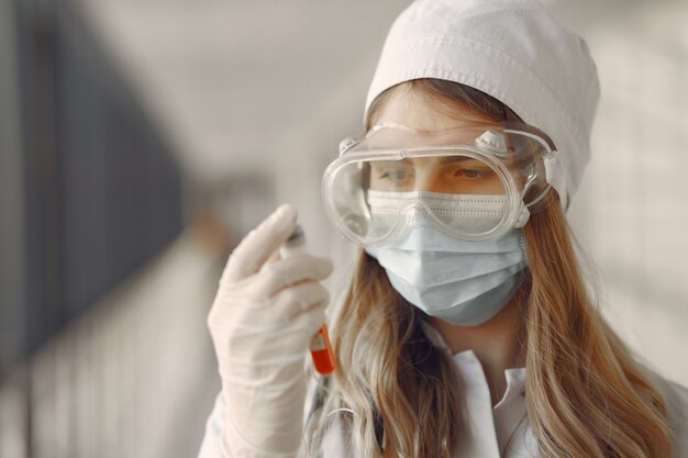 Donna in una maschera e uniforme in possesso di un tubo nelle sue mani