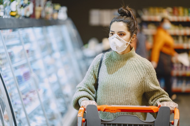 Donna in una maschera protettiva in un supermercato