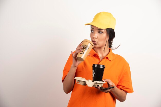 Donna in uniforme che beve da una tazza di caffè