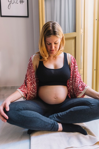 Donna incinta accanto alla finestra aperta