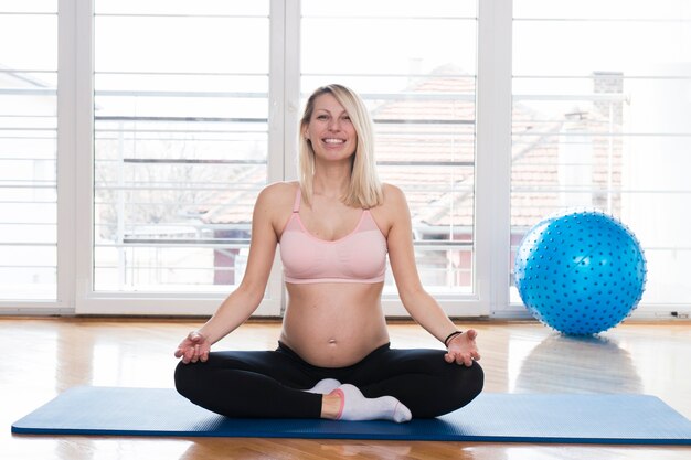 Donna incinta che fa yoga in palestra