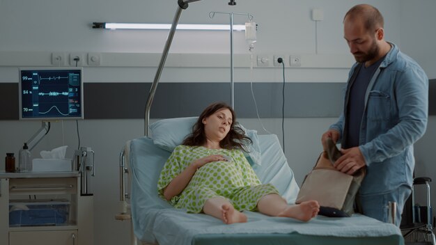 Donna incinta che giace nel letto del reparto ospedaliero in attesa di assistenza