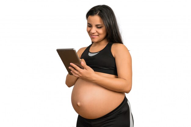 Donna incinta che per mezzo della compressa digitale.