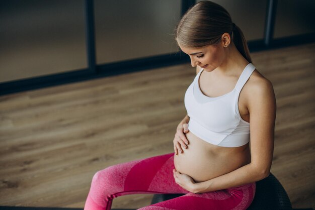 Donna incinta che si esercita su una classe di pilates