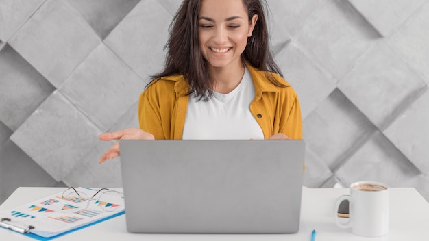 Donna incinta di smiley che lavora con il computer portatile a casa