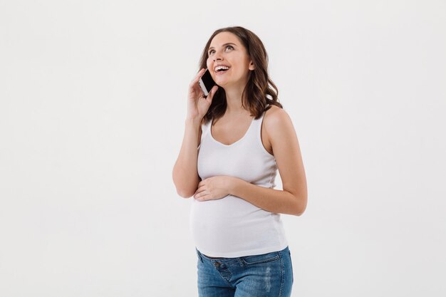 Donna incinta felice che parla dal telefono cellulare