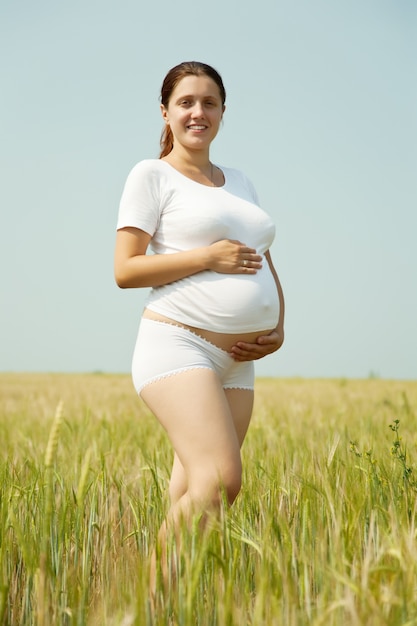 Donna incinta nel campo di grano