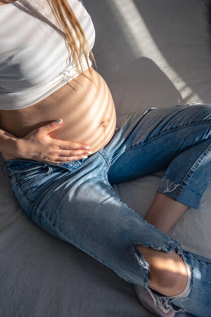 Donna incinta sul letto in camera in una mattina di sole