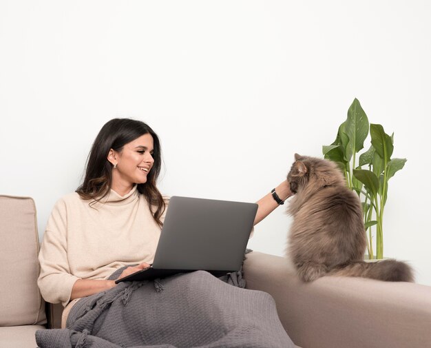 Donna indipendente che gioca con il gatto mentre si lavora