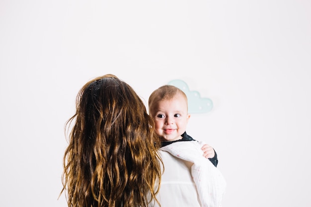 Donna irriconoscibile che abbraccia bambino sorridente